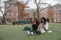 a girl and a boy are sitting in fron of their campus